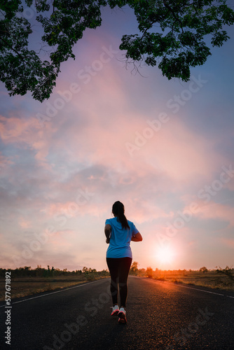 Young fitness asian woman is running and jogging an outdoor workout on the road in the morning for lifestyle health.