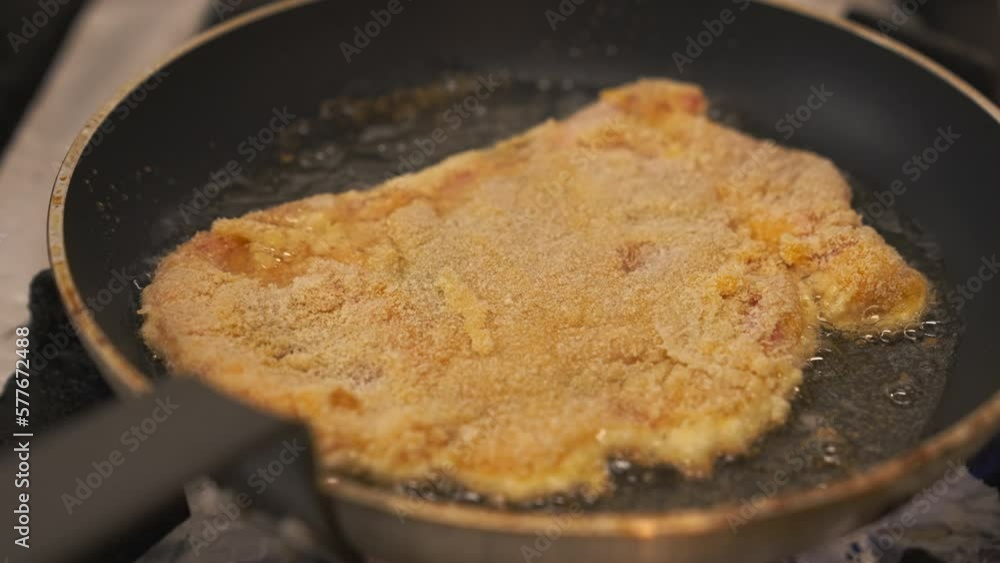 Schabowy Kotlet frying on a non-stick pan with less oil Polish pork breaded cutlet. High-quality 4k footage Schabowy Kotlet frying on a non-stick pan with less oil Polish pork breaded cutlet. High-quality 4k footage