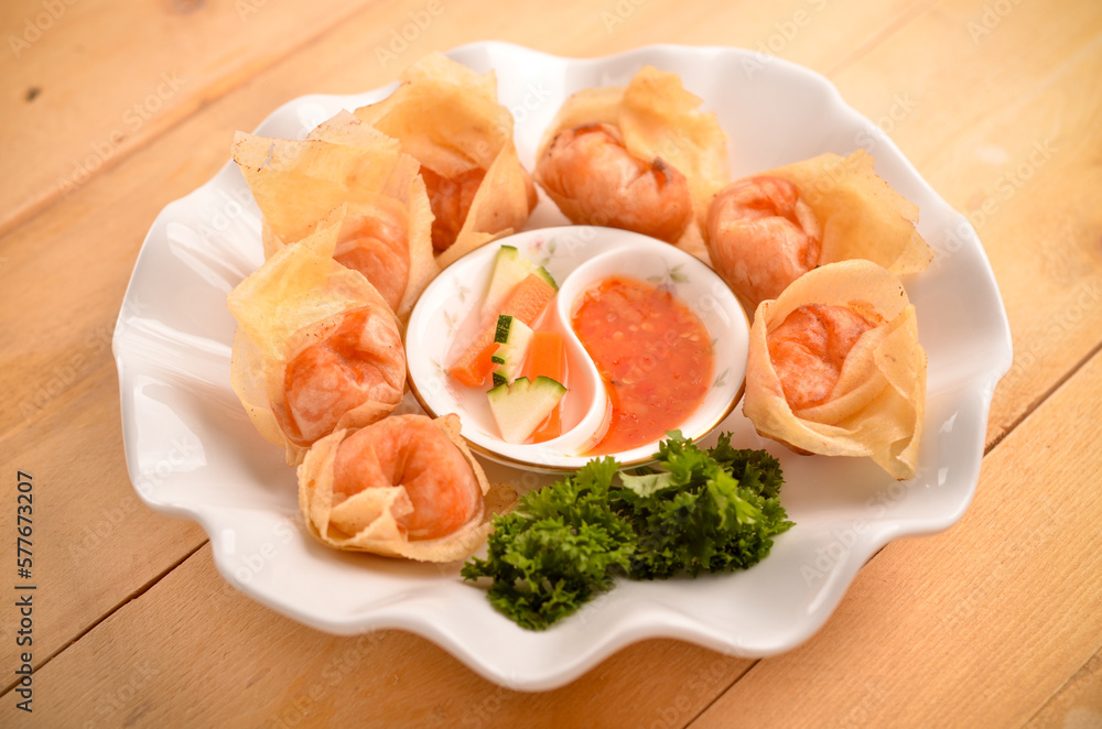 Chinese dumpling recipe called fried wontons eated by onion sauce isolated on wood table
Chinese dumpling recipe called fried wontons eated by onion sauce isolated on wood table