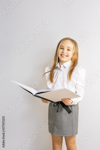 Cute little girl reading book on white background. smiling girl holding a book. free time, kid is ready to study.