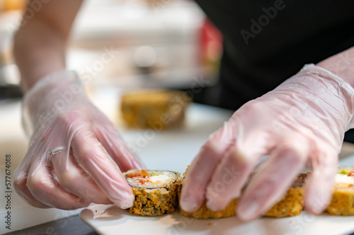 professional chef's hands making sushi and rolls in a restaurant kitchen photo