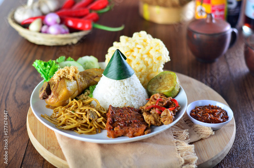 Indonesian nasi campur with fried chicken, noodles, eggs, tempeh and vegetables. photo
