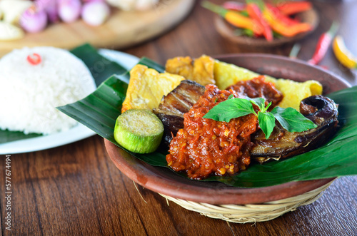 penyetan ikan tempe tahu,traditional food from Indonesia chili sambal with tempeh and tofu, wooden background,