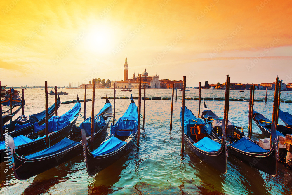 Magic cityscape with gondolas on the San Marco canal on the background of Church of San Giorgio Maggiore at sunset in Venice, Italia, Europe.