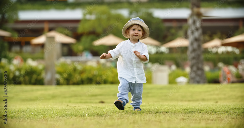 child one years old smiling running along the grass in the park. Childhood, Children Day, vacation, travel, adventure, happy baby, ,