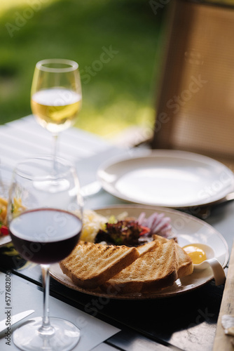 Beef tartar with grated butter and raw chicken yolk served with roasted bread. Glass of white and red wine