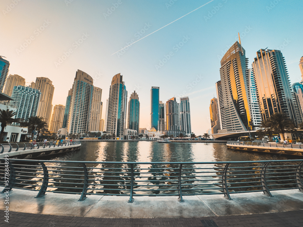 Fototapeta premium Dubai Marina, harbour, cruise boat and canal promenade view at sunset, in Dubai, United Arab Emirates