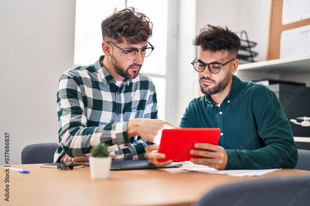 Fototapeta premium Young couple business workers using touchpad working at office