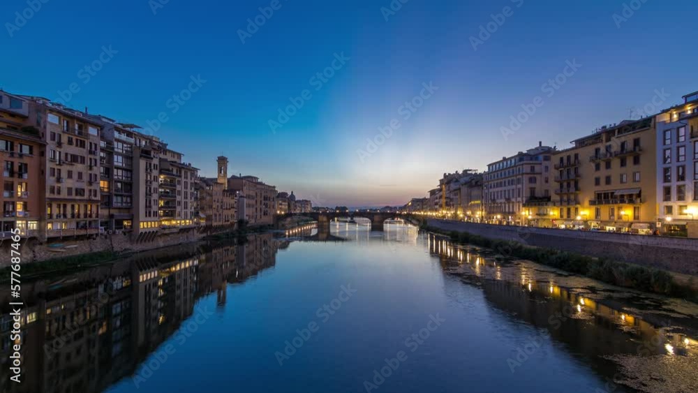Twilight scene of Ponte Santa Trinita (Holy Trinity Bridge) day to night transition panoramic timelapse over River Arno with reflections on water after sunset, old houses on the side. Florence, Italy Twilight scene of Ponte Santa Trinita (Holy Trinity Bridge) day to night transition panoramic timelapse over River Arno with reflections on water after sunset, old houses on the side. Florence, Italy