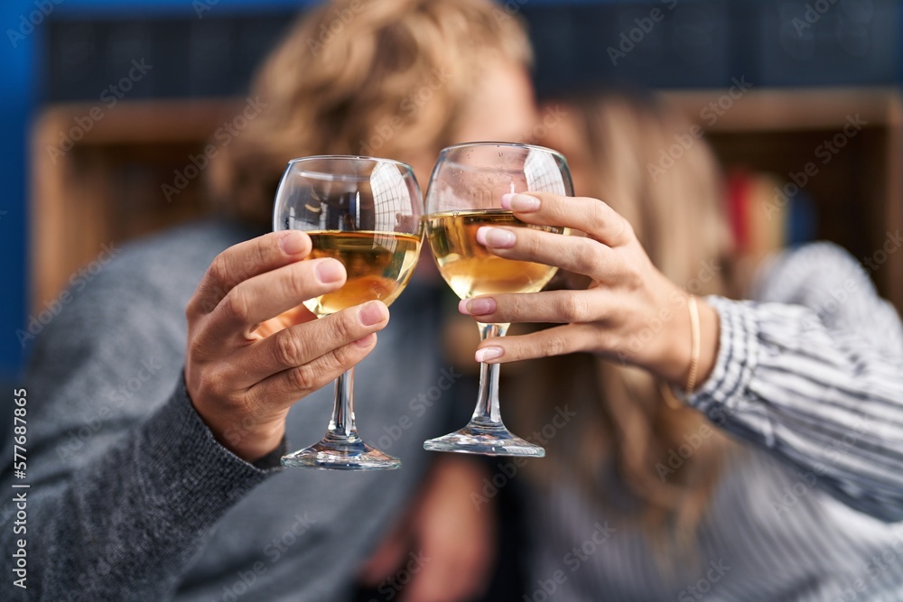 Man and woman couple kissing and toasting with glass of champagne at home