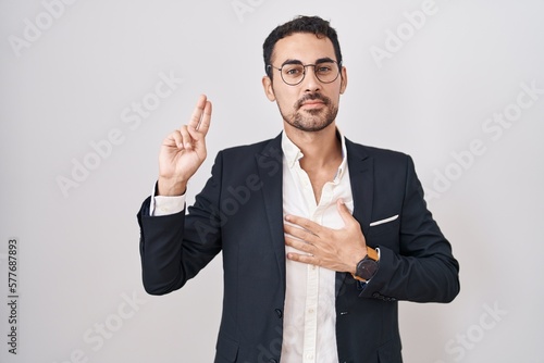 Fotografia Handsome business hispanic man standing over white background smiling swearing w