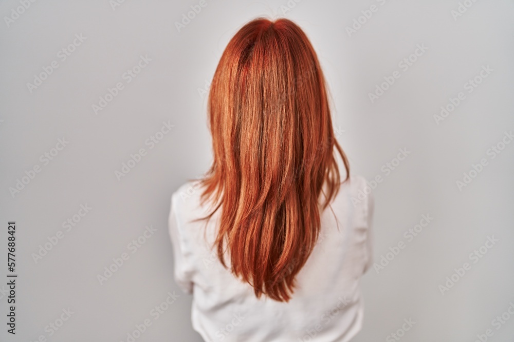 Young caucasian woman standing over isolated background standing backwards looking away with crossed arms Young caucasian woman standing over isolated background standing backwards looking away with crossed arms