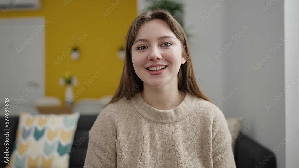 Young blonde woman smiling confident sitting on sofa at home Young blonde woman smiling confident sitting on sofa at home