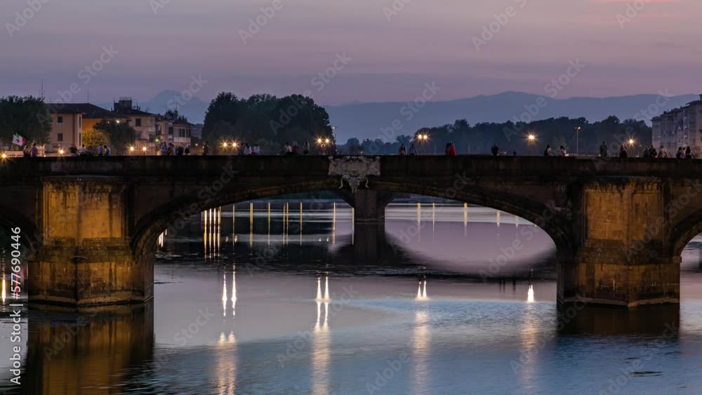 Twilight scene of Ponte Santa Trinita (Holy Trinity Bridge) day to night transition timelapse over River Arno with reflections on water after sunset. Close up view. Florence, Tuscany, Italy Twilight scene of Ponte Santa Trinita (Holy Trinity Bridge) day to night transition timelapse over River Arno with reflections on water after sunset. Close up view. Florence, Tuscany, Italy