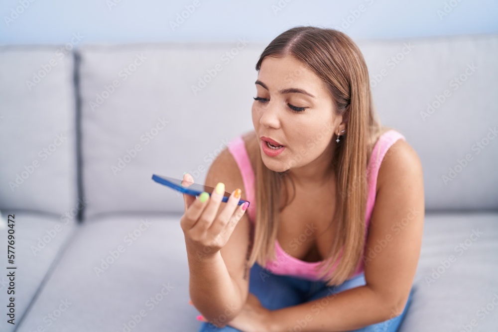 Young beautiful hispanic woman talking on the smartphone sitting on sofa at home Young beautiful hispanic woman talking on the smartphone sitting on sofa at home