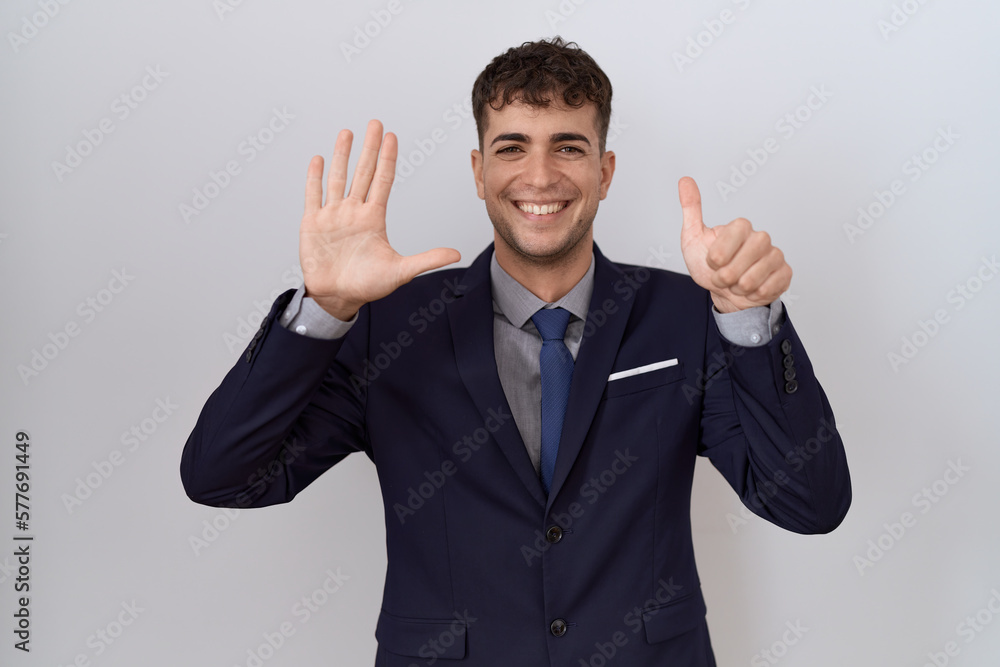 Young hispanic business man wearing suit and tie showing and pointing up with fingers number six while smiling confident and happy. Young hispanic business man wearing suit and tie showing and pointing up with fingers number six while smiling confident and happy.