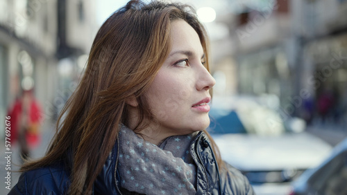 Young beautiful hispanic woman looking to the side with serious expression at street