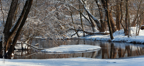 Panoramic photography. A corner of a wild forest with an unfrozen river. Snow. Frost on the trees. Landscape Evening light. Frost and sun