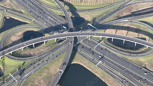 A mesmerizing aerial drone video of a bustling highway multilevel intersection captures the intricate web of roads and vehicles.