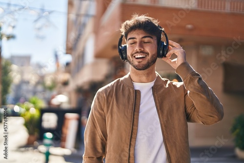 Young hispanic man smiling confident listening to music at street © Krakenimages.com