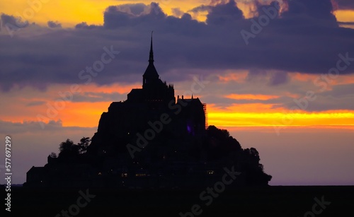 Silhouette of the famous Mont Saint Michel Abbey in Normandy in France and the colors of sunset
