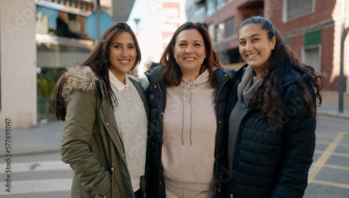 Mother and daugthers smiling confident hugging each other at street