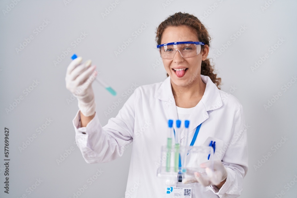 Young caucasian scientist woman working with laboratory samples sticking tongue out happy with funny expression. Young caucasian scientist woman working with laboratory samples sticking tongue out happy with funny expression.