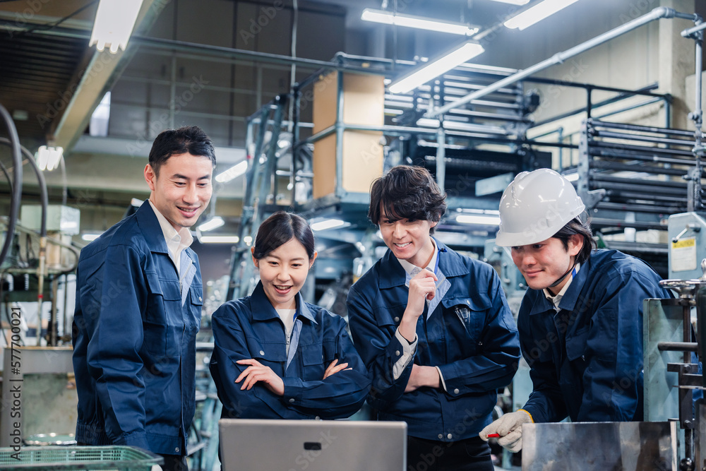 パソコンを見ながら議論をする工場スタッフ