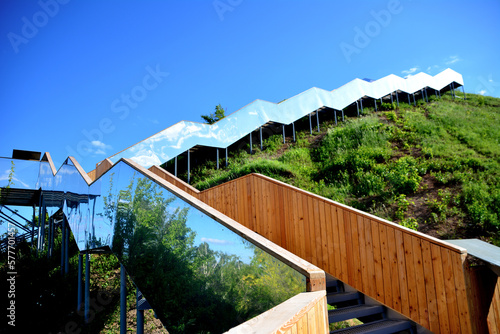 A staircase with mirror railings leads up to a blue sky isolated closeup