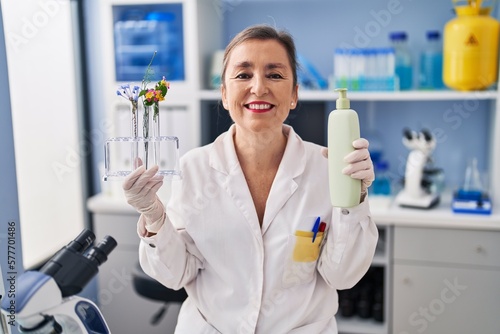 Middle age hispanic woman working at cosmetics laboratory smiling with a happy and cool smile on face. showing teeth.
