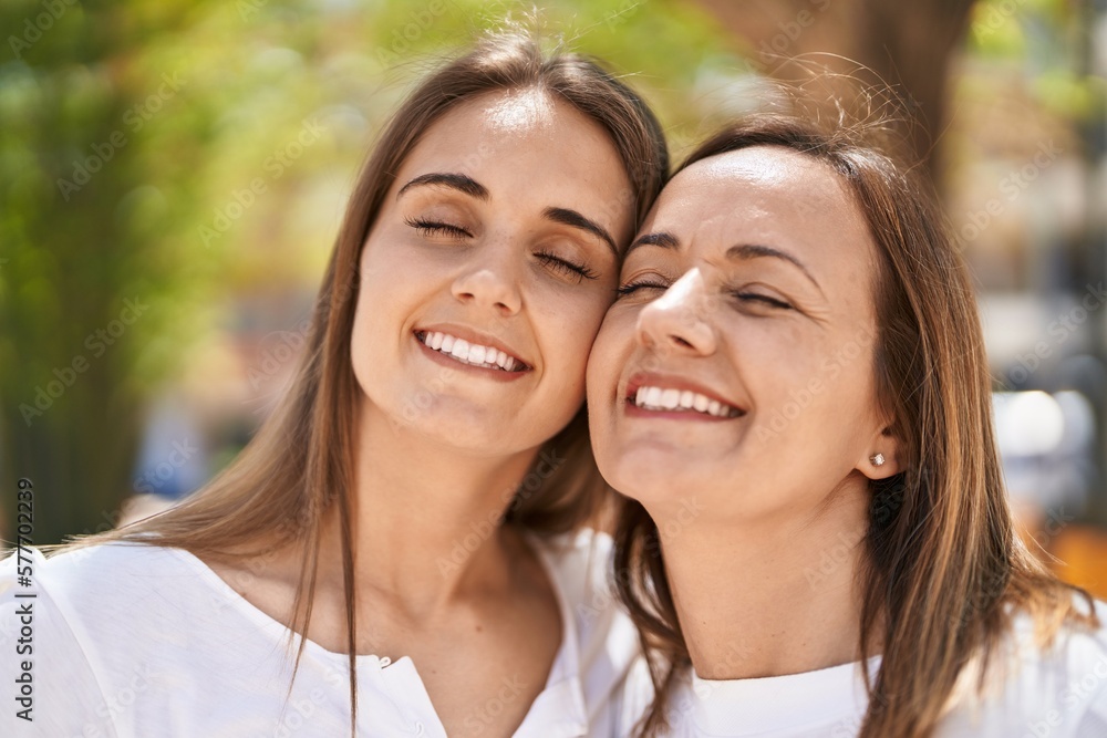 Two women mother and daughter standing together at park Two women mother and daughter standing together at park
