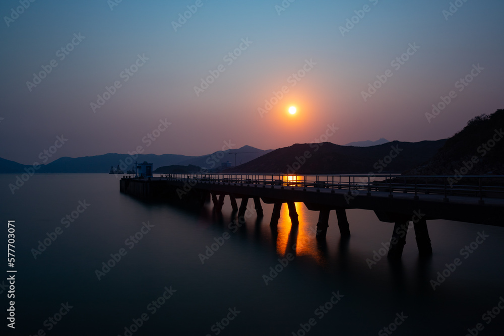Looking west. Joss House Bay pier at sunset. Long exposure, smooth sea, orange sun reflection. Looking west. Joss House Bay pier at sunset. Long exposure, smooth sea, orange sun reflection.