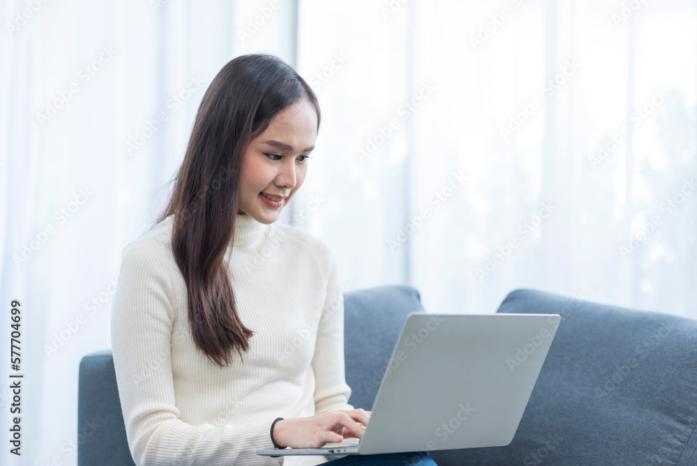 Portrait of Asian young woman doing with computer notebook with happy in love moment in living room Portrait of Asian young woman doing with computer notebook with happy in love moment in living room