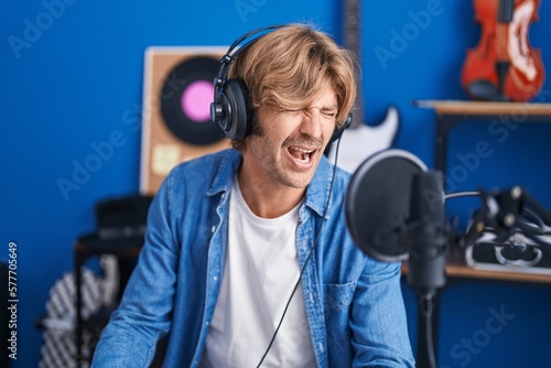 Young man artist singing song at music studio