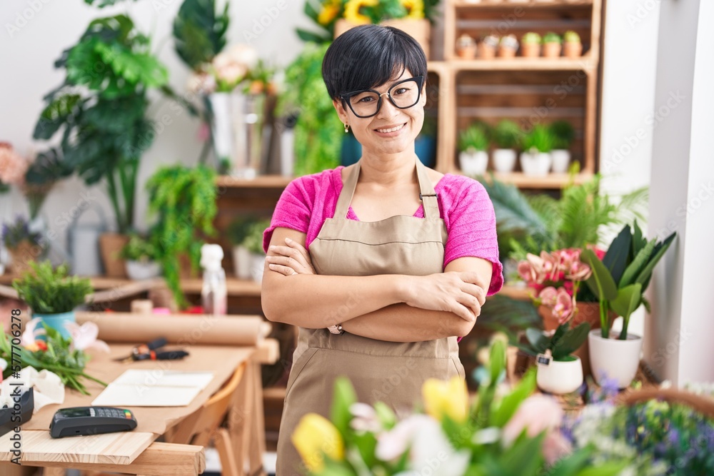 Middle age chinese woman florist smiling confident standing with arms crossed gesture at flower shop