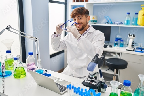 Young arab man scientist using laptop working at laboratory