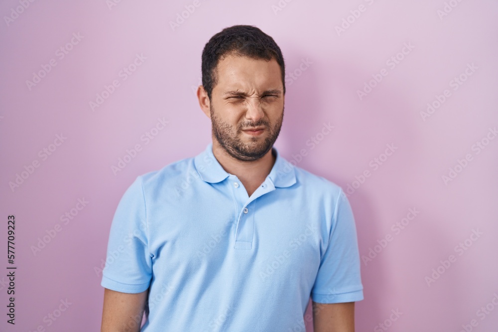 Hispanic man standing over pink background skeptic and nervous, frowning upset because of problem. negative person. Hispanic man standing over pink background skeptic and nervous, frowning upset because of problem. negative person.