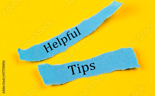 Obraz na plátne HELPFUL TIPS text on a blue pieces of paper on yellow background, business conce