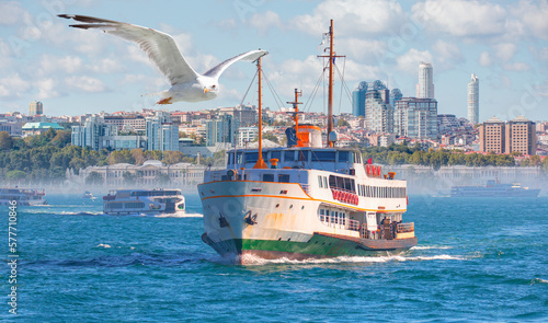 Dolmabahce palace against coastal cityscape with modern buildings under cloudy sky - Sea voyage with old ferry (steamboat) on the Bosporus - Istanbul, Turkey 