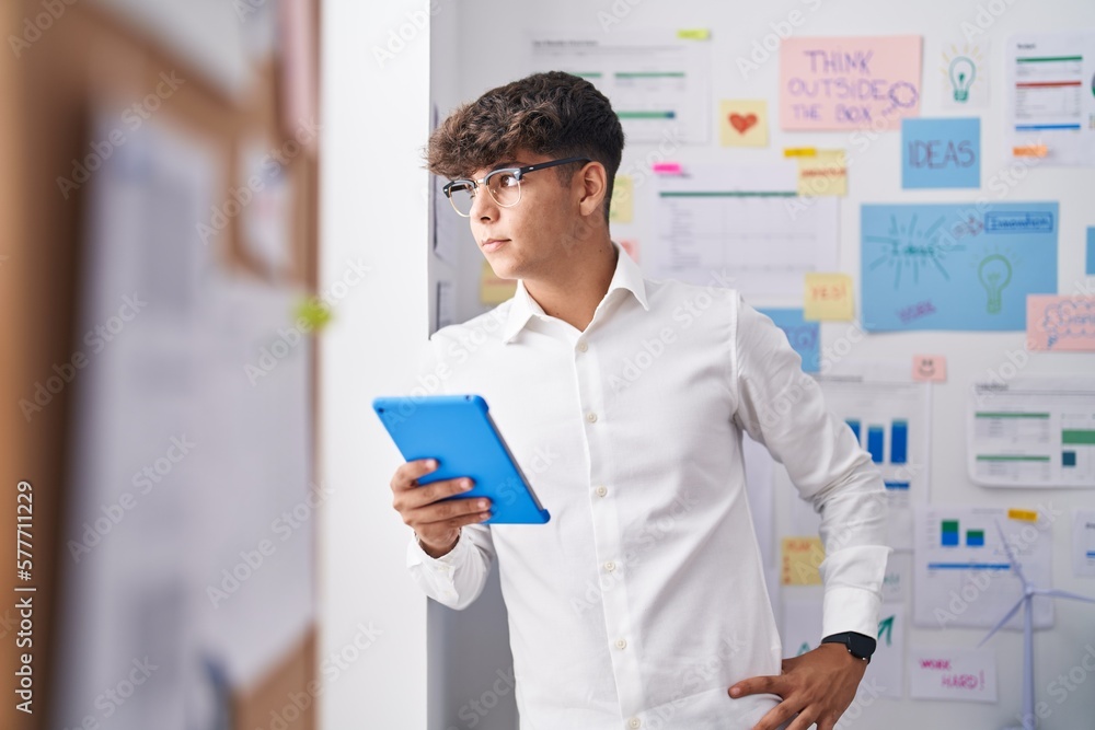 Young hispanic teenager business worker using touchpad at office Young hispanic teenager business worker using touchpad at office