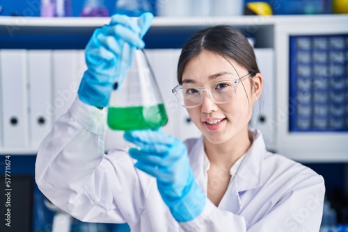 Chinese woman scientist measuring liquid working at laboratory