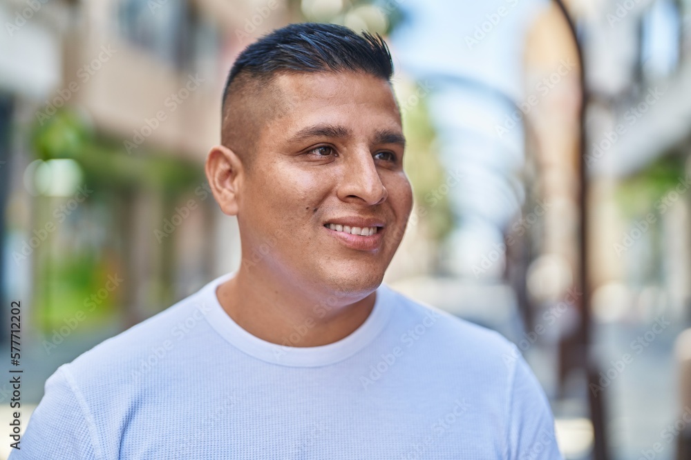 Young latin man smiling confident looking to the side at street Young latin man smiling confident looking to the side at street