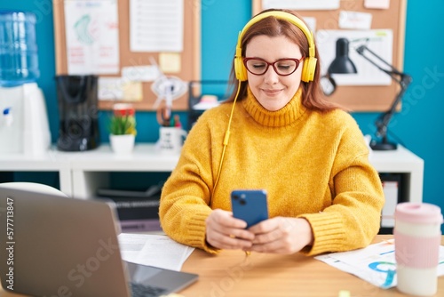 Young beautiful plus size woman business worker listening to music at office