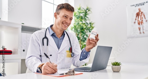 Young man doctor prescribing pills treatment writing on document at clinic