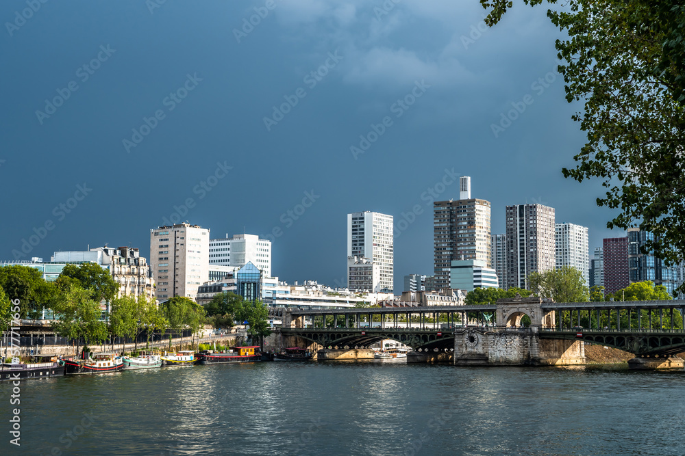 Obraz premium River Seine In Paris, France With Promenade, Anchored Houseboats And Modern Office Buildings