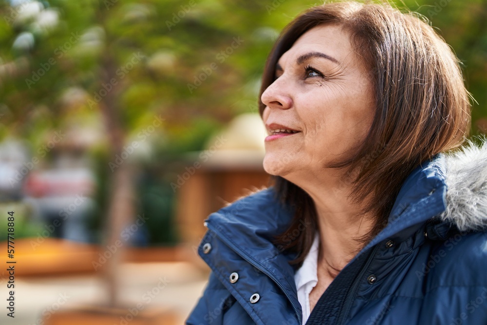 Middle age woman smiling confident looking to the side at park Middle age woman smiling confident looking to the side at park
