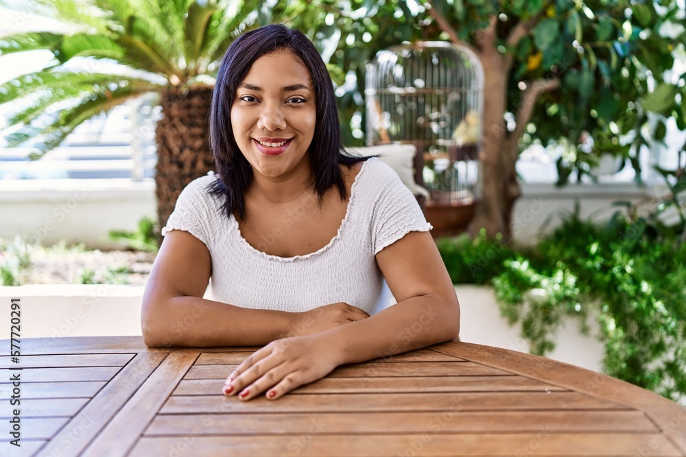 Naklejka premium Hispanic brunette woman sitting at the terrace