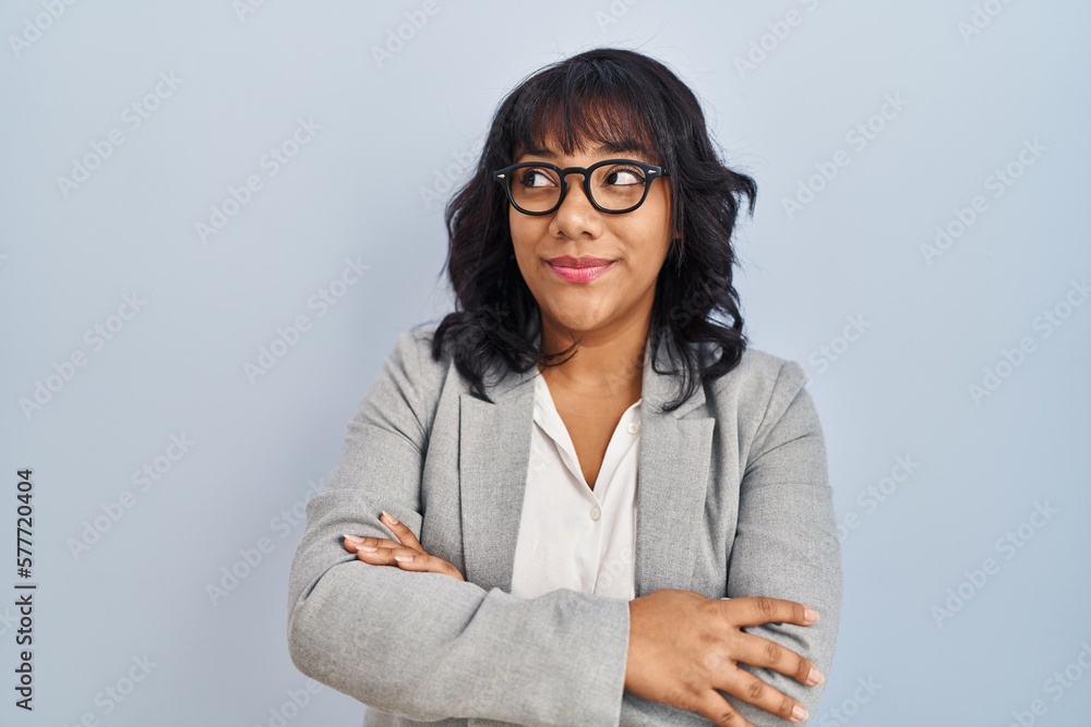 Hispanic woman standing over isolated background smiling looking to the side and staring away thinking.