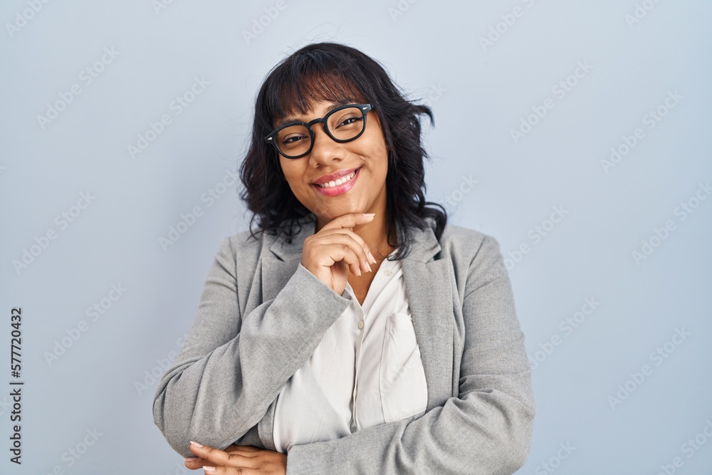 Hispanic woman standing over isolated background looking confident at the camera smiling with crossed arms and hand raised on chin. thinking positive. Hispanic woman standing over isolated background looking confident at the camera smiling with crossed arms and hand raised on chin. thinking positive.