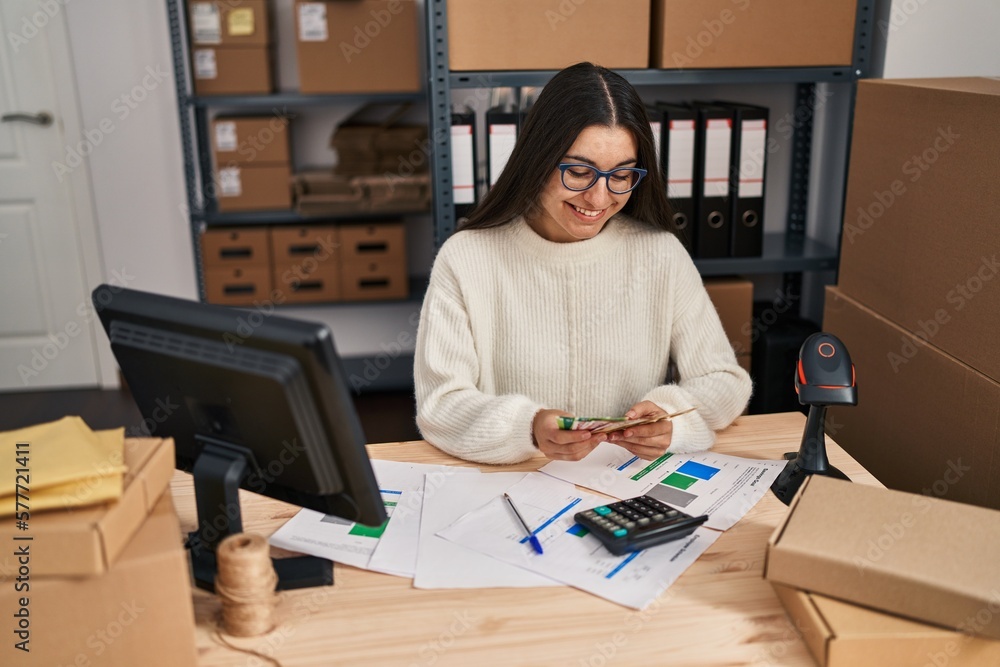 Young hispanic woman ecommerce business worker holding krone banknotes at office Young hispanic woman ecommerce business worker holding krone banknotes at office